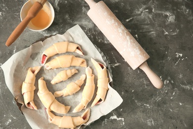 Photo of Baking dish with raw croissants on table, top view