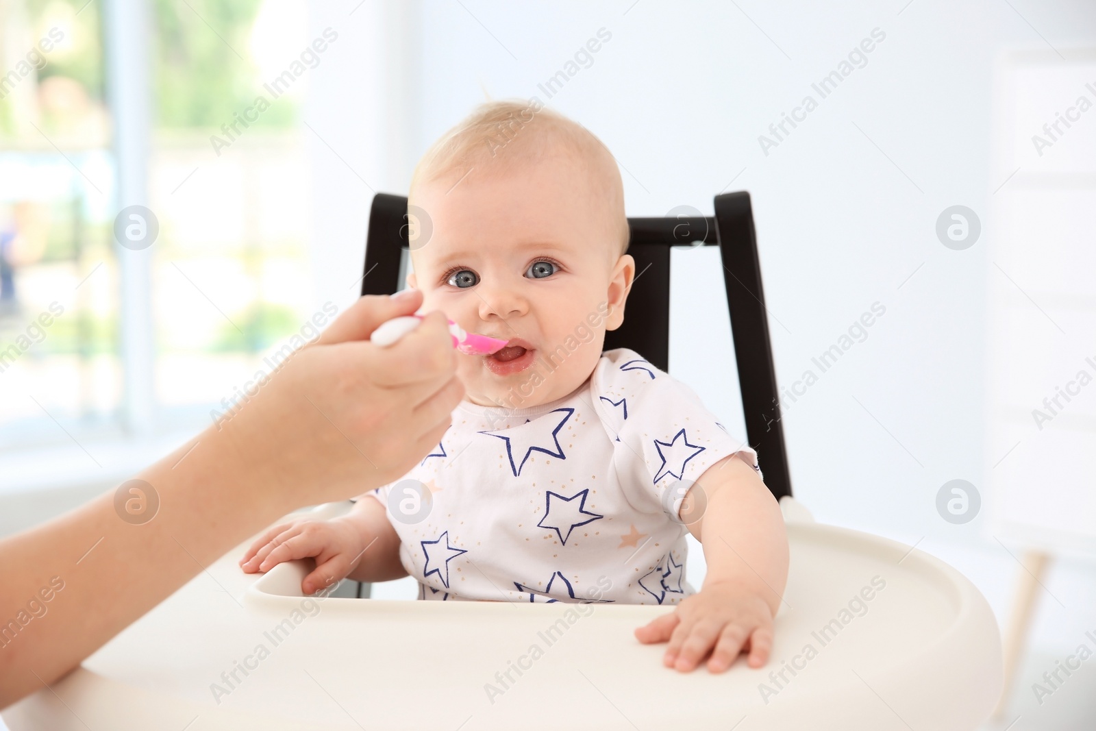 Photo of Mother feeding her cute little baby at home