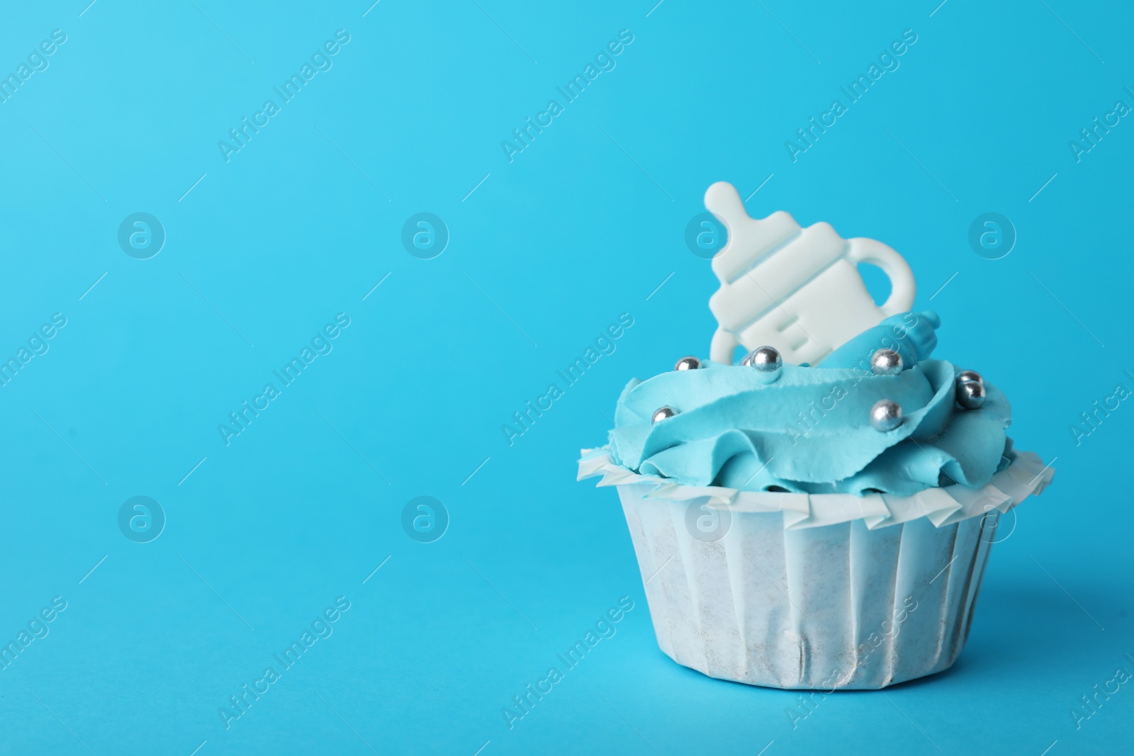Photo of Baby shower cupcake with topper on light blue background, space for text