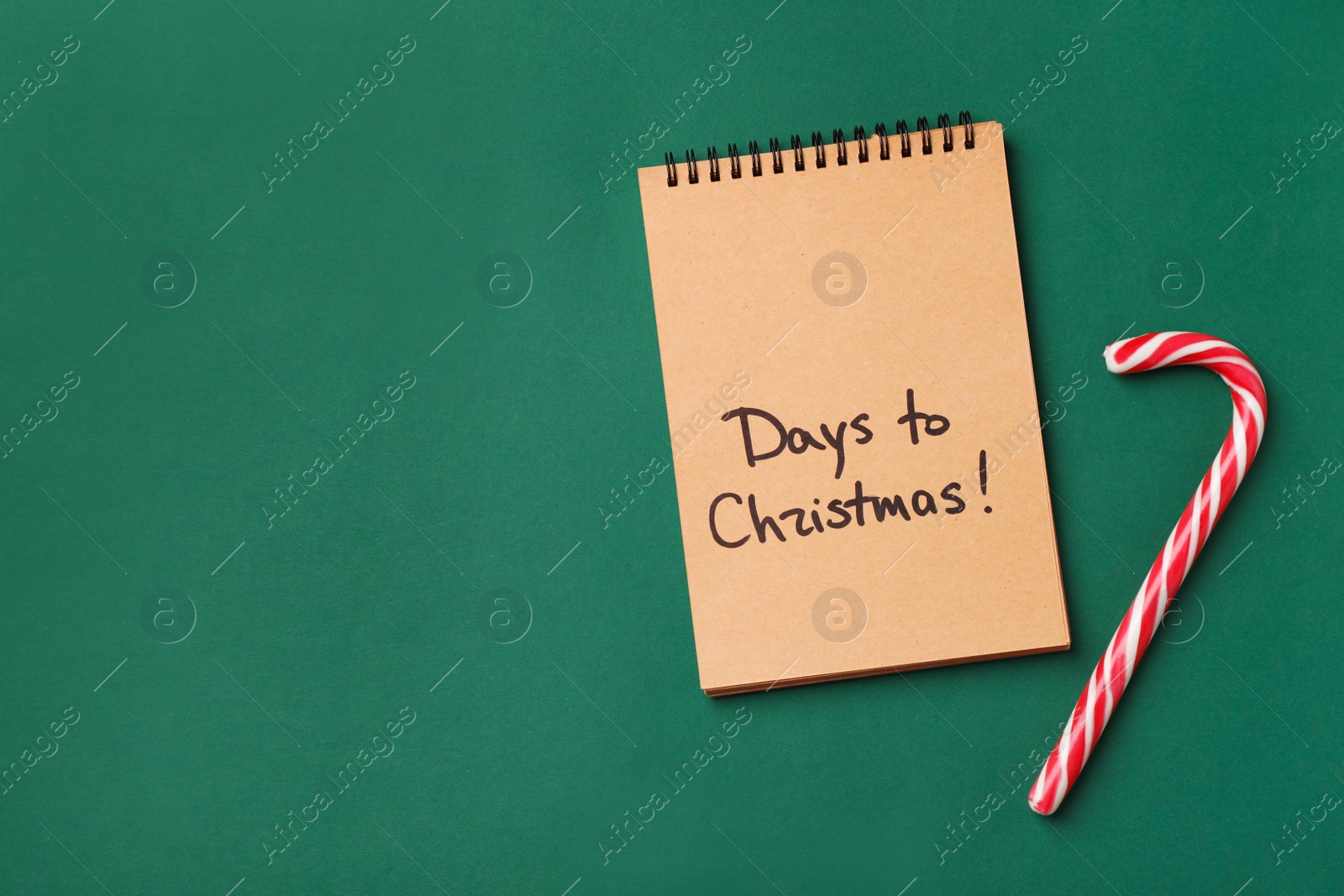 Photo of Notebook and candy cane on color background, top view. Christmas countdown