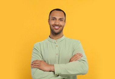 Photo of Portrait of handsome young man on orange background