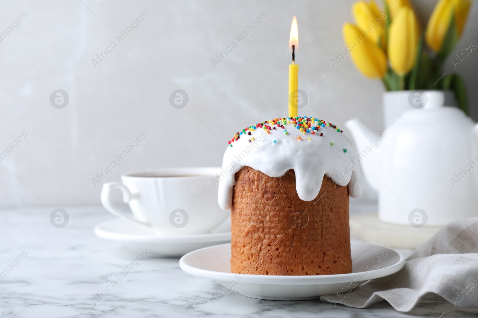 Photo of Beautiful Easter cake with candle on white marble table. Space for text