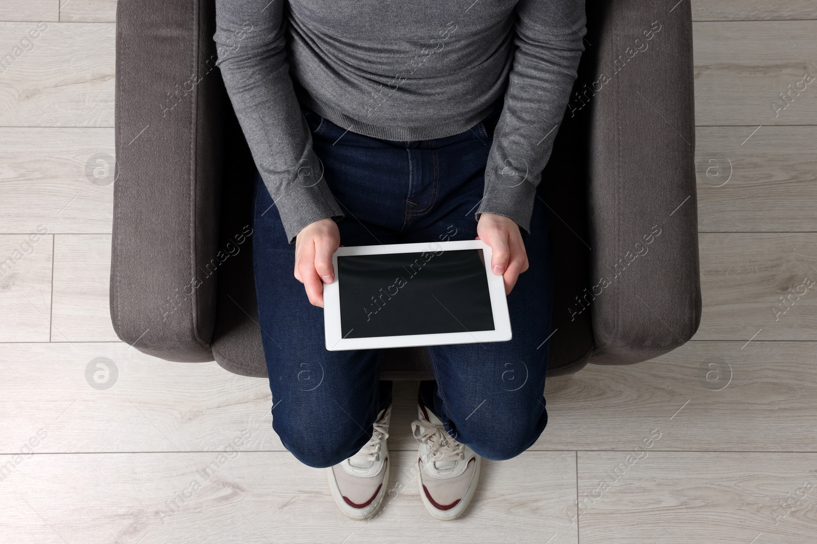 Photo of Man working with tablet in armchair, top view