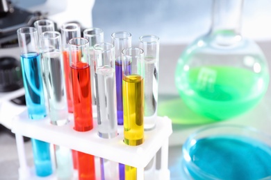 Photo of Test tubes with samples in rack on table at chemistry laboratory, closeup