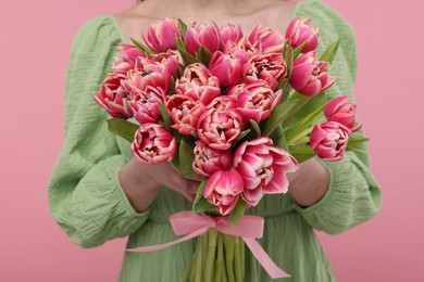Photo of Woman with beautiful bouquet on dusty pink background, closeup