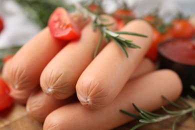 Photo of Delicious boiled sausages and rosemary on table, closeup