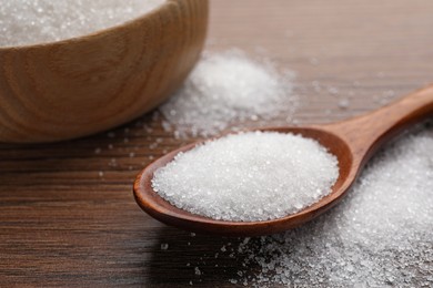 Granulated sugar on wooden table, closeup view