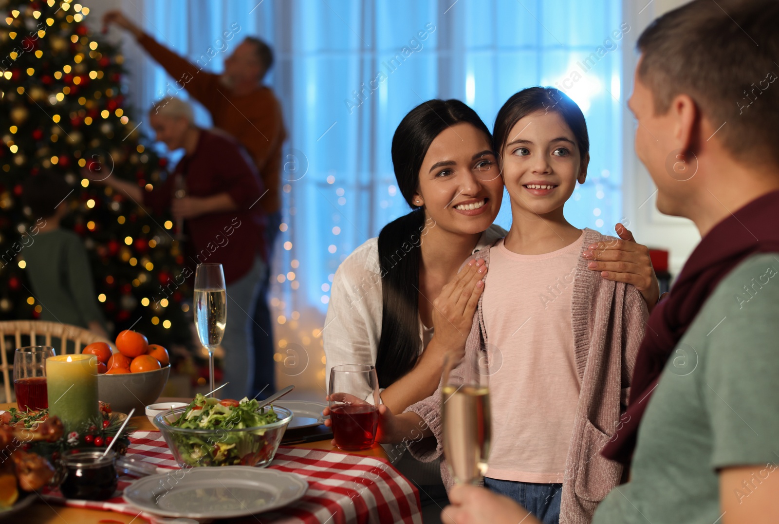 Photo of Happy family celebrating Christmas at home in evening