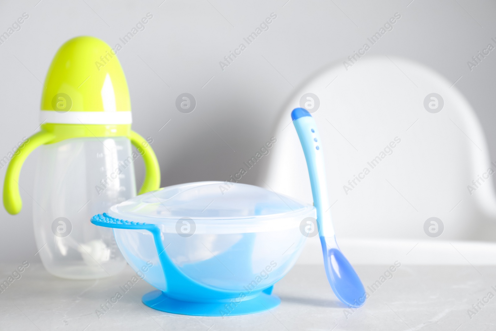 Photo of Set of plastic dishware on white table. Serving baby food