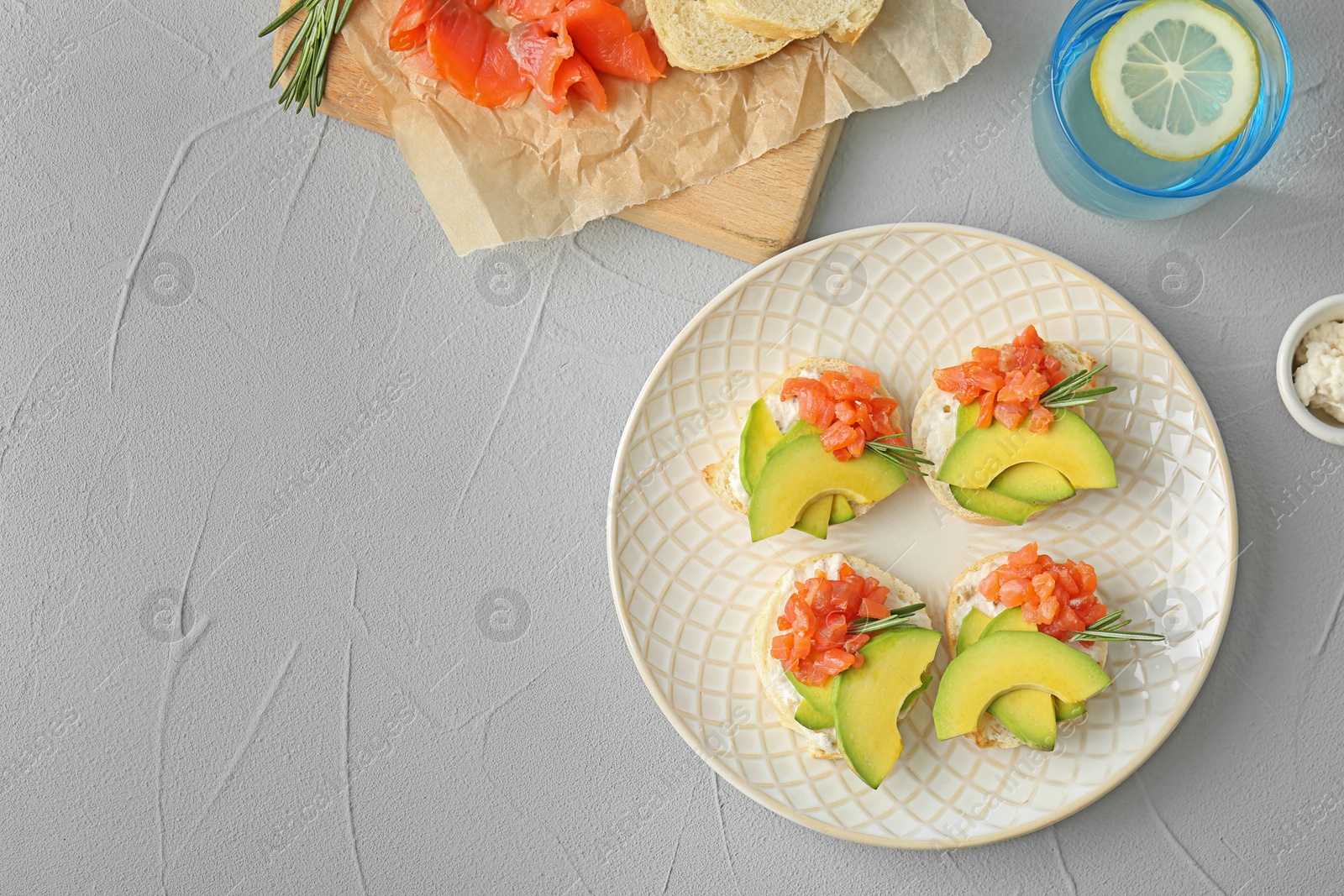 Photo of Plate of tasty sandwiches with fresh sliced salmon fillet and avocado on table, top view