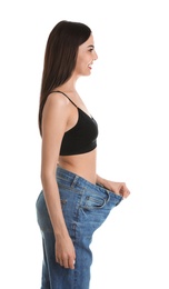 Photo of Attractive young woman with slim body wearing her old big jeans on white background