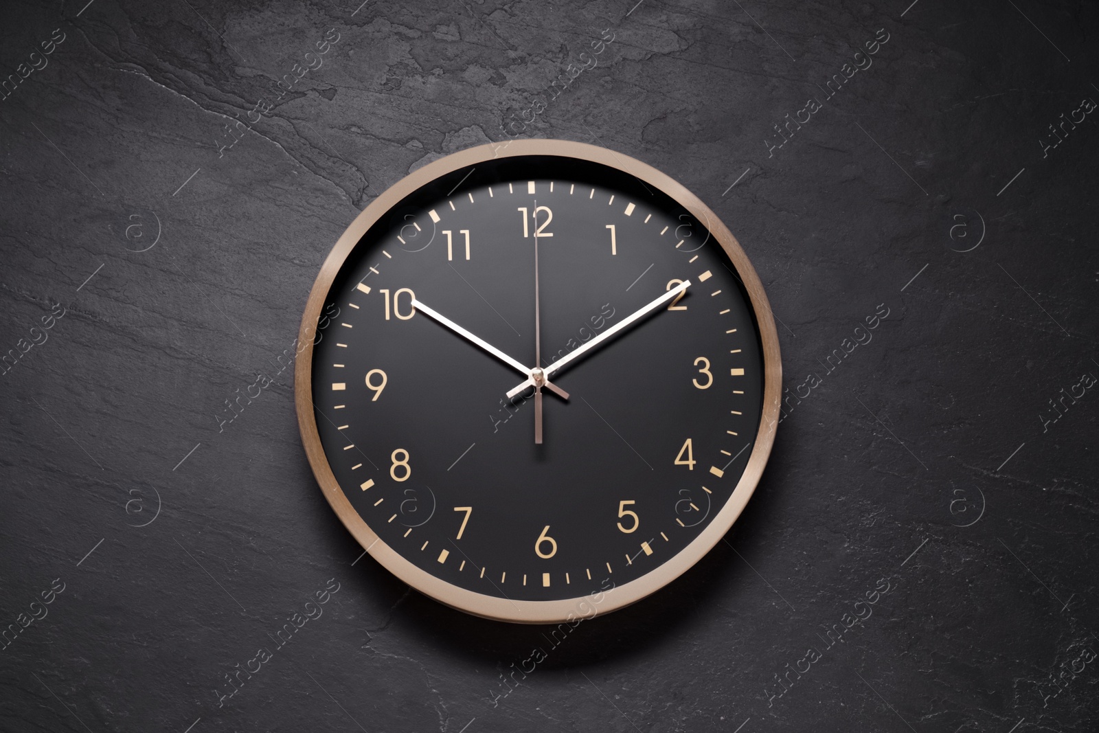 Photo of Stylish round clock on black table, top view. Interior element
