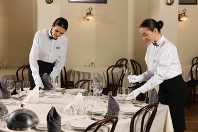 Photo of People setting table during professional butler courses in restaurant