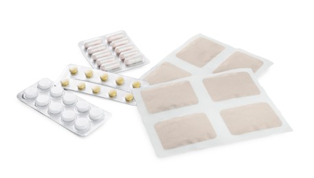 Photo of Mustard plasters and pills on white background