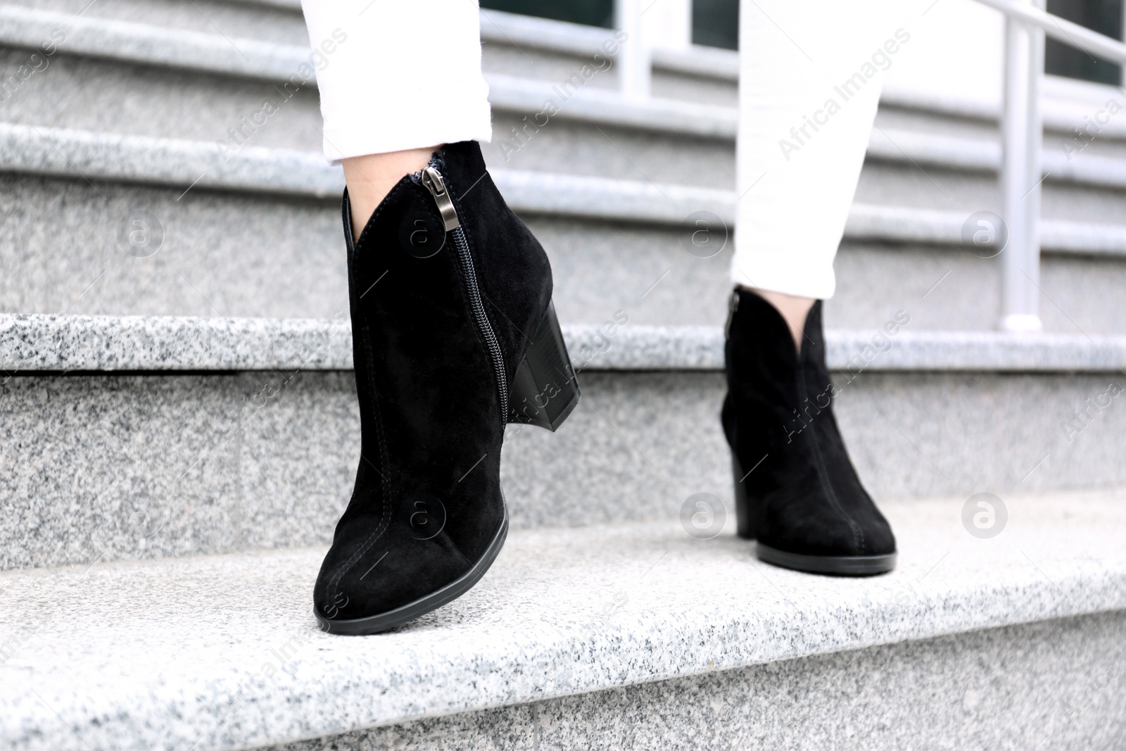 Photo of Woman in stylish boots on stairs outdoors, closeup