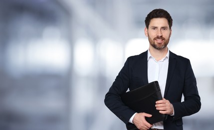 Image of Handsome real estate agent with portfolio in office, space for text