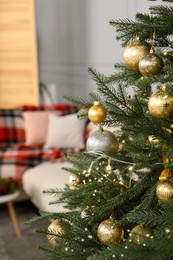 Christmas tree with golden and silver balls in living room