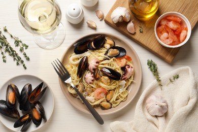 Photo of Delicious pasta with sea food served on white wooden table, flat lay