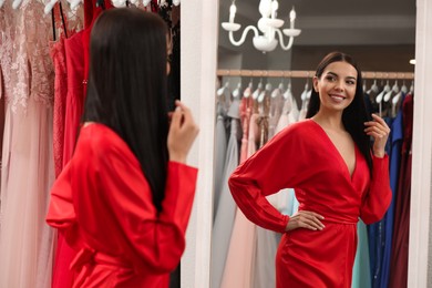 Photo of Woman trying on dress in clothing rental salon