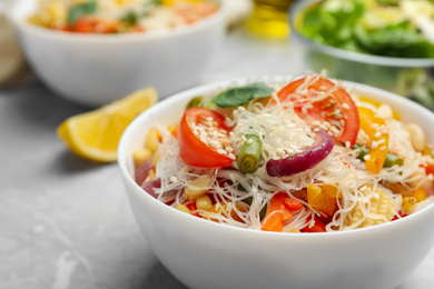 Photo of Tasty cooked rice noodles with vegetables on table, closeup