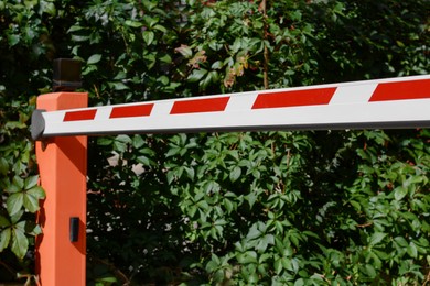 Photo of Closed boom barrier outdoors on sunny day, closeup
