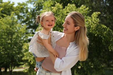 Happy mother with her daughter having fun in park