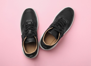 Photo of Pair of stylish shoes on pink background, top view