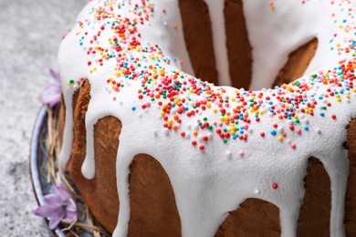 Photo of Glazed Easter cake with sprinkles on grey table, closeup