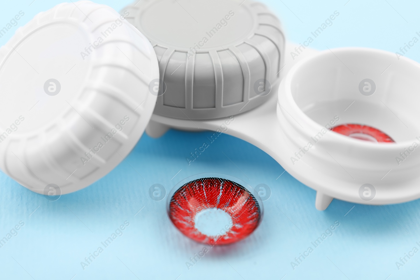 Photo of Case with red contact lenses on light blue background