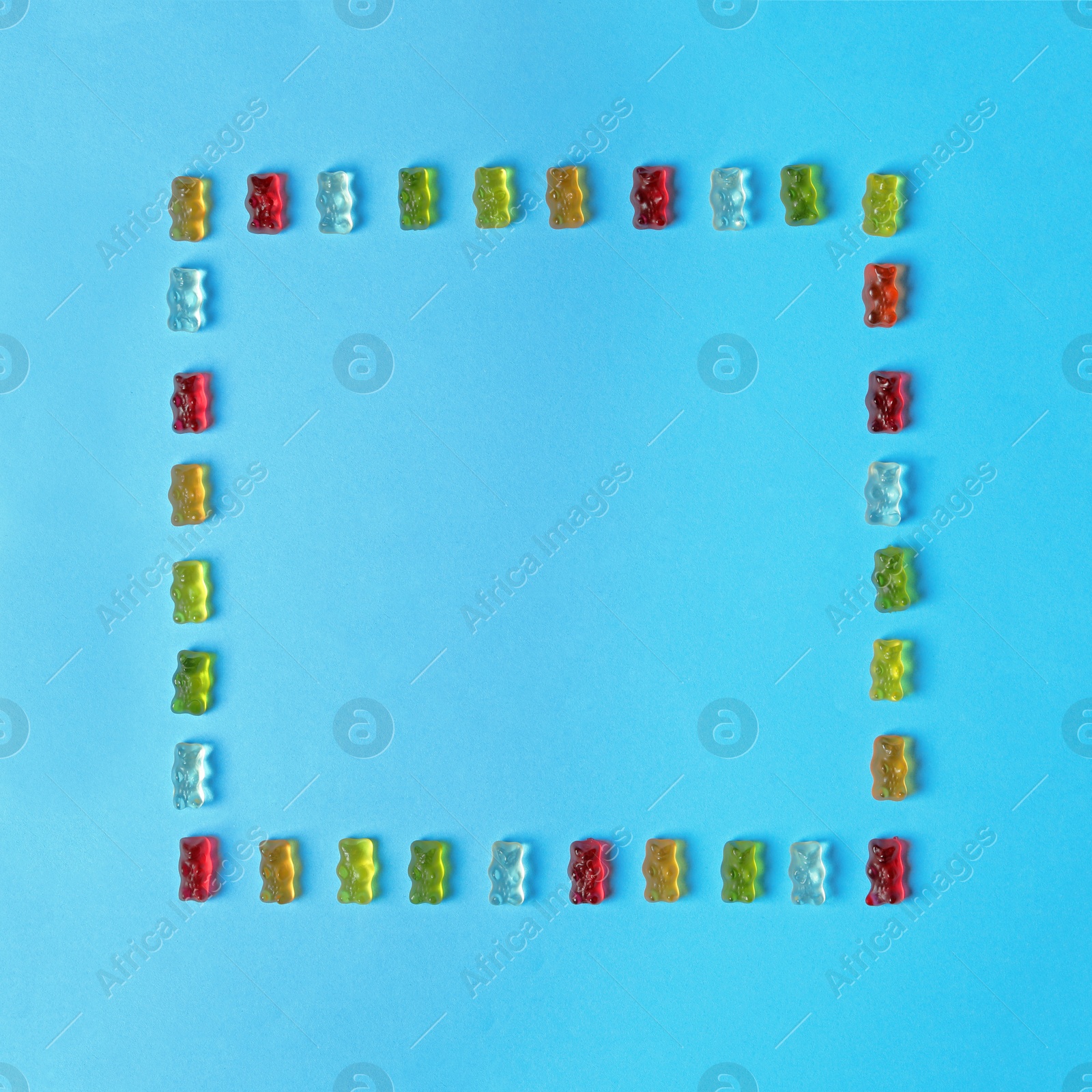 Photo of Flat lay composition with delicious jelly bears on color background. Space for text