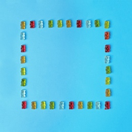 Photo of Flat lay composition with delicious jelly bears on color background. Space for text