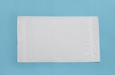 White beach towel on light blue background, top view