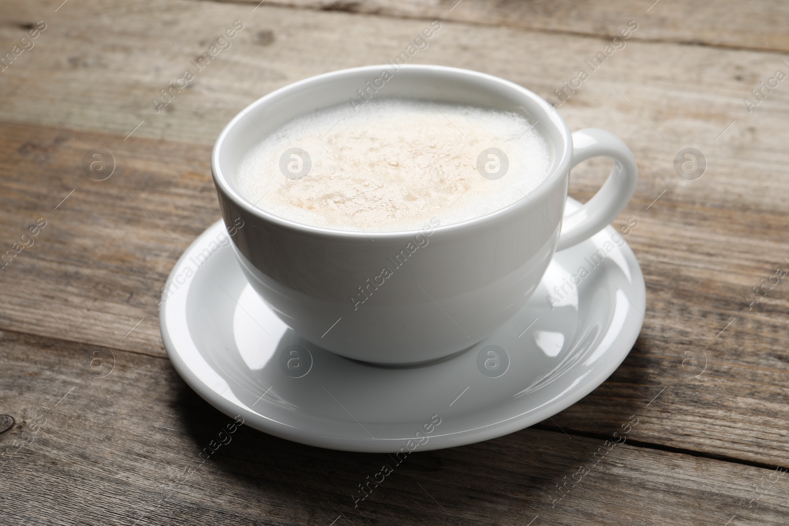 Photo of Aromatic coffee in cup on wooden table