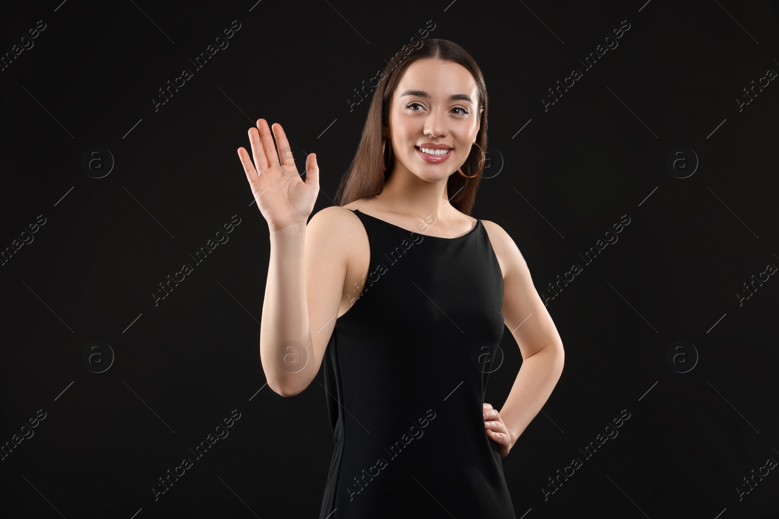 Photo of Beautiful young woman in elegant dress on black background