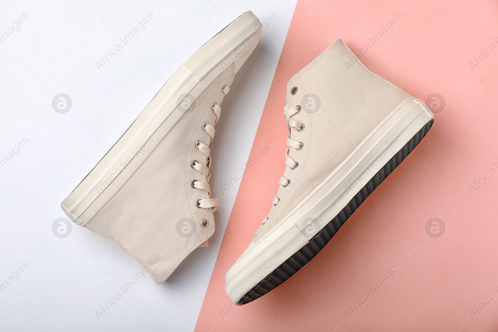 Photo of Pair of stylish sneakers on color background, top view