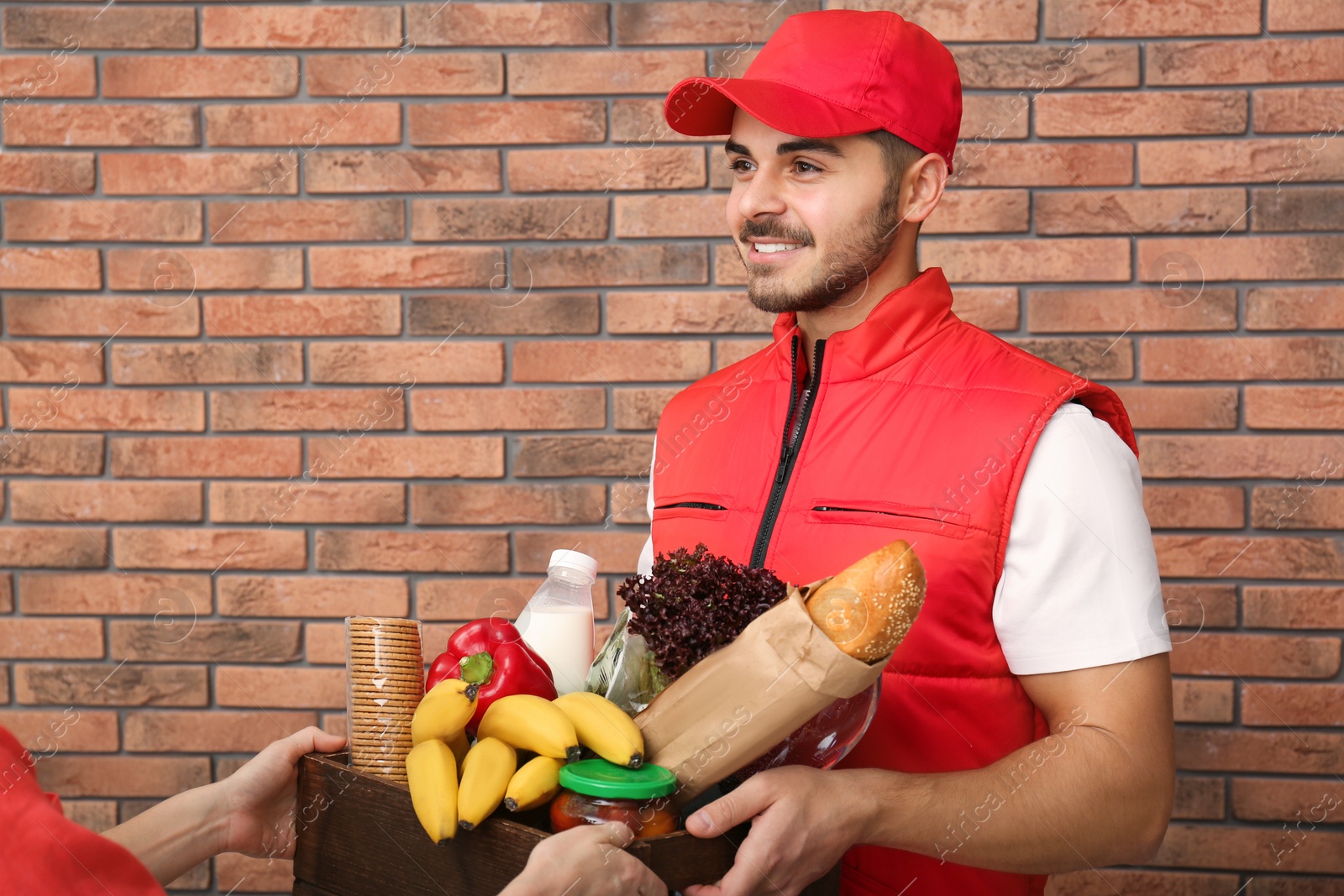 Photo of Male courier delivering food to client indoors