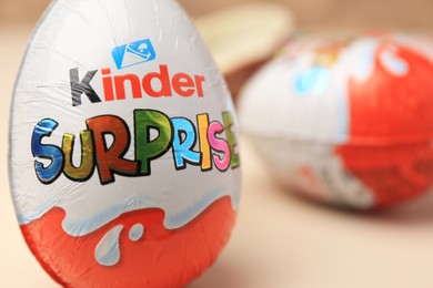 Photo of Slynchev Bryag, Bulgaria - May 25, 2023: Kinder Surprise Eggs on beige background, closeup. Space for text