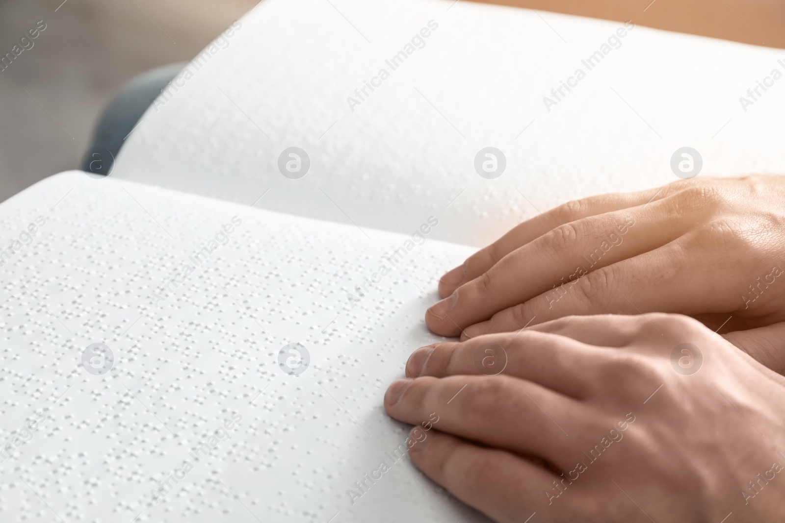 Photo of Blind man reading book written in Braille, closeup