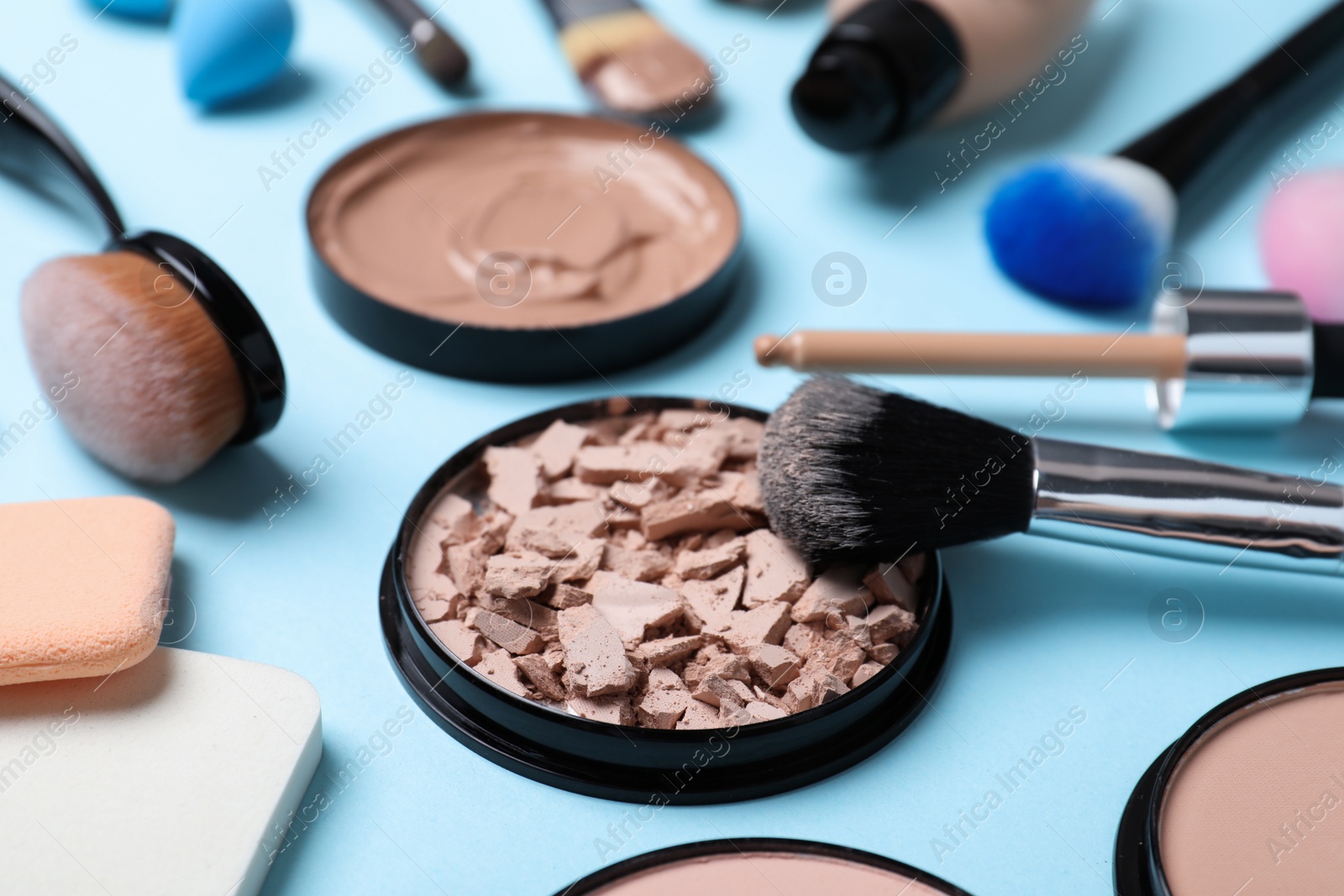 Photo of Composition with powder, skin foundation and beauty accessories on color background