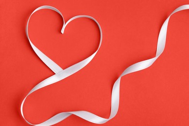 Photo of Heart made of white ribbon on red background, top view. Valentine's day celebration