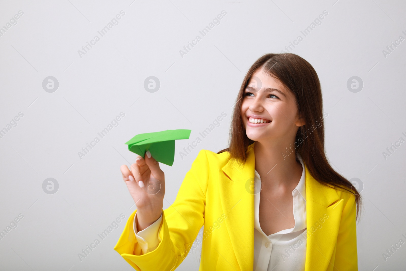 Photo of Beautiful teenage girl with paper plane on grey background
