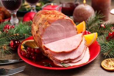 Plate with delicious ham served on wooden table. Christmas dinner