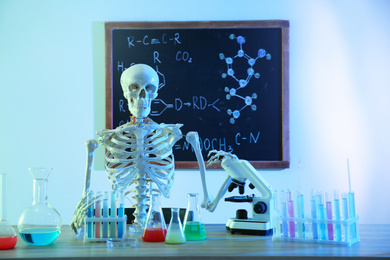 Photo of Skeleton and different chemistry glassware in classroom, toned in blue