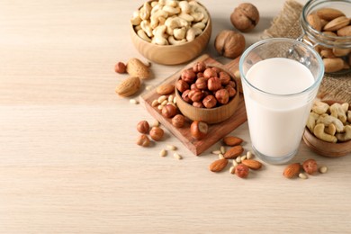 Vegan milk and different nuts on wooden table