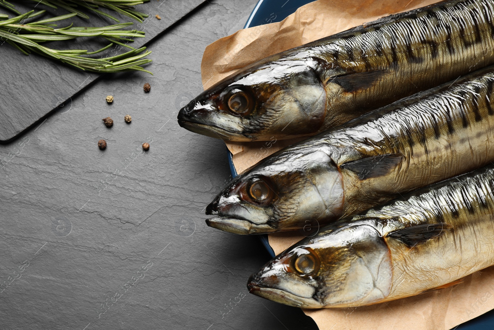 Photo of Tasty smoked fish on black table, closeup