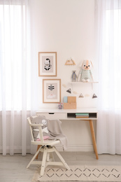 Stylish child's room interior with desk and beautiful pictures