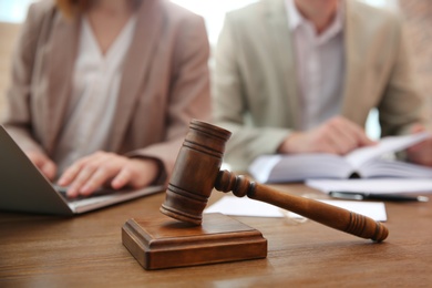 Photo of Notaries working at table in office, focus on judge gavel. Law and justice concept