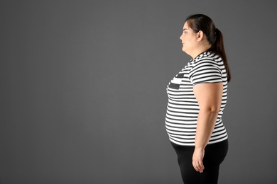 Portrait of overweight woman and space for text on gray background