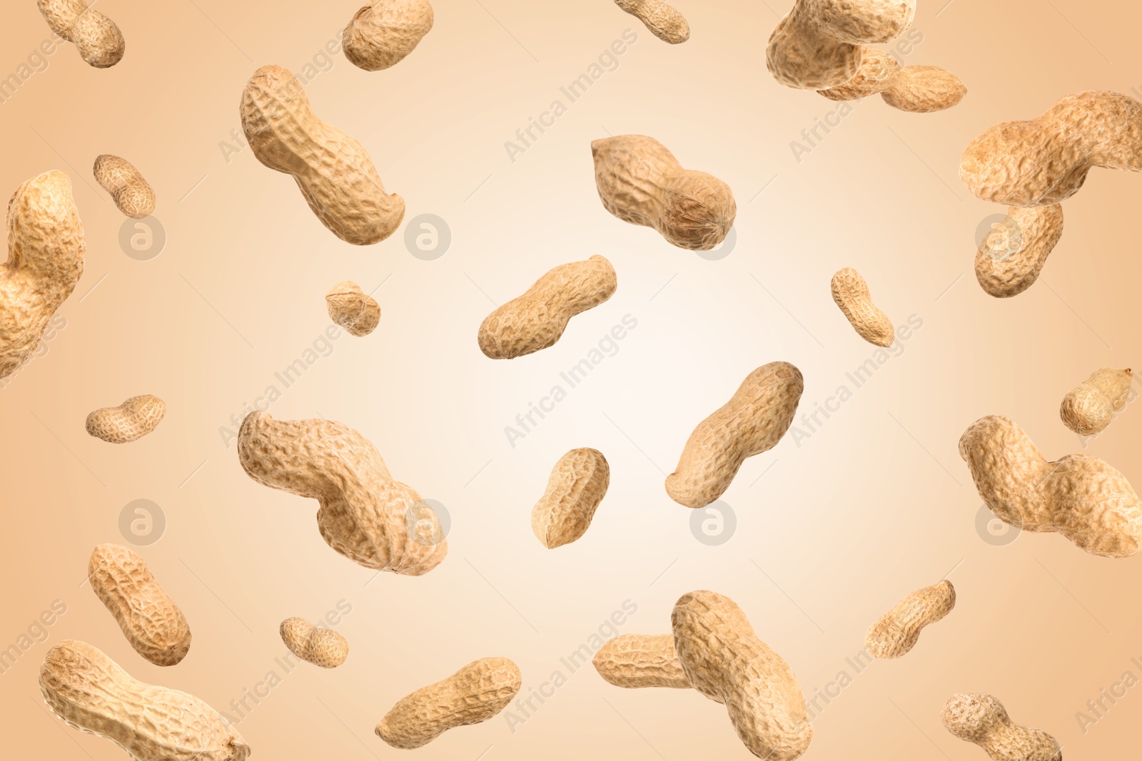 Image of Unpeeled peanuts in air on beige background