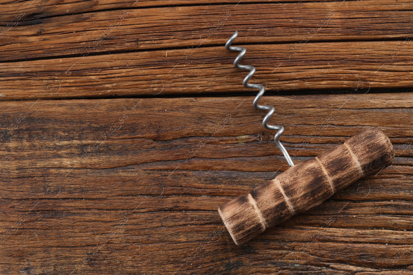 Photo of One corkscrew on wooden table, top view. Space for text